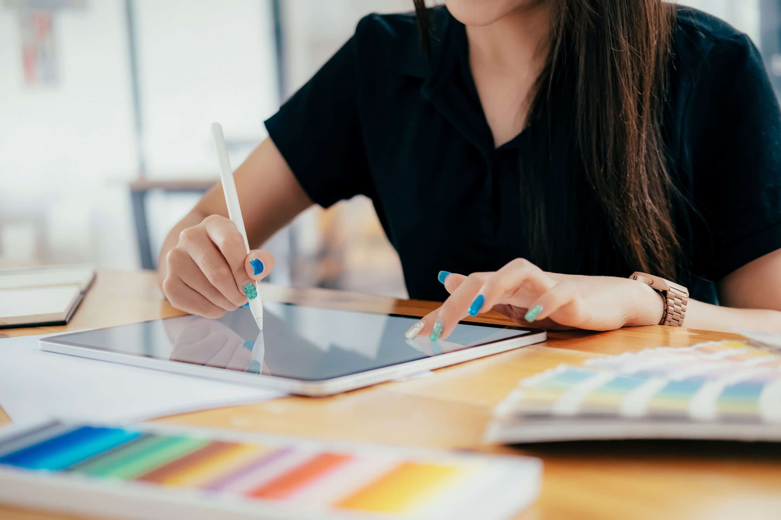 Graphic designer working at her desk in creative studio office.